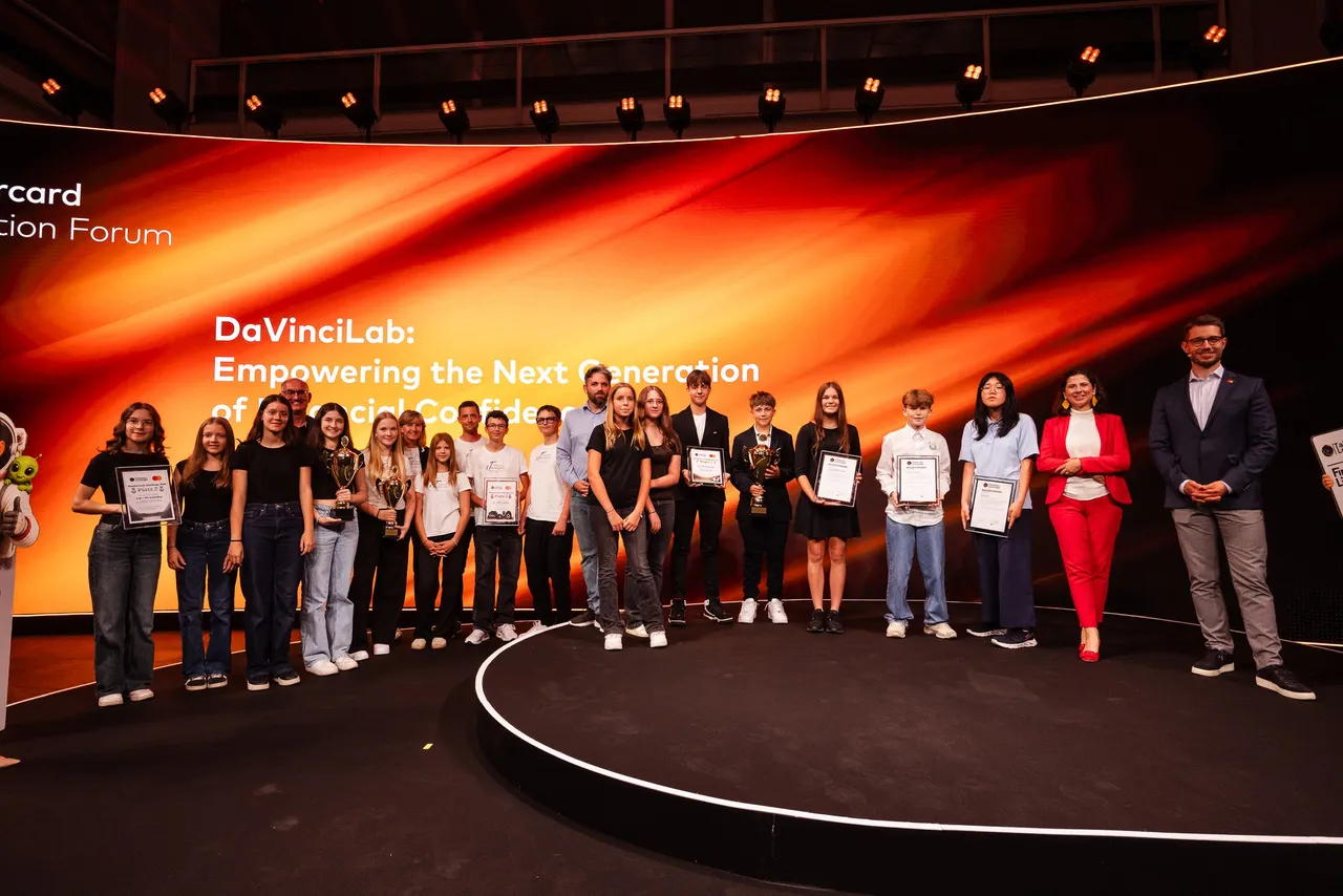 Alle ausgezeichneten Schulklassen stehen mit Pokalen und Urkunden auf der Bühne des Mastercard Innovation Forum
