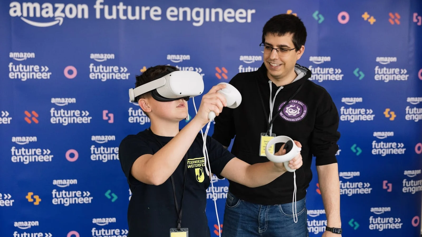 Schüler probiert bei einem Amazon-Future-Engineer-Event eine VR-Brille aus, daneben ein Mitarbeiter