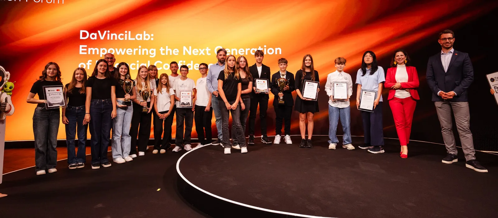 Alle ausgezeichneten Schulklassen der Mastercard Finanzchallenge 2026 mit Pokalen und Urkunden auf der Bühne des Mastercard Innovation Forum